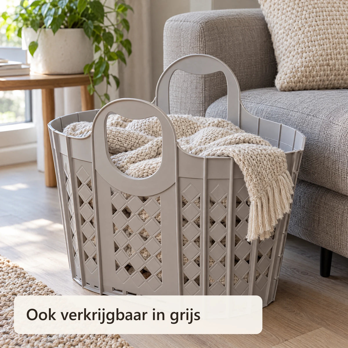 Grijze opvouwbare wasmand naast de bank