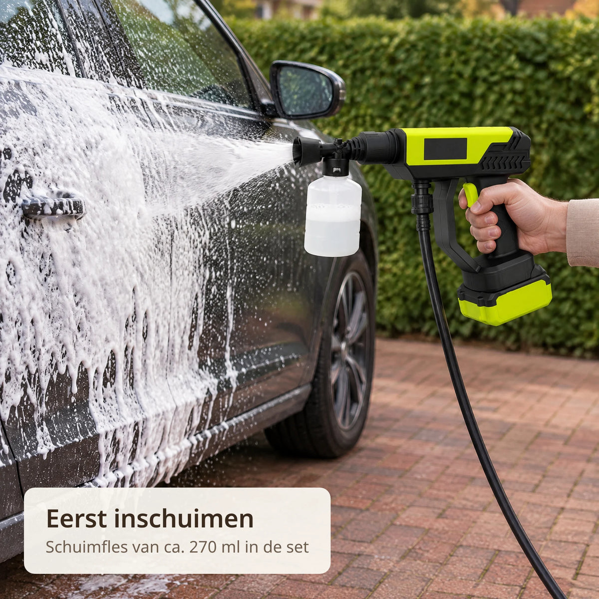 Accu hogedrukreiniger met schuimfles spuit wit schuim op het portier van een donkere auto