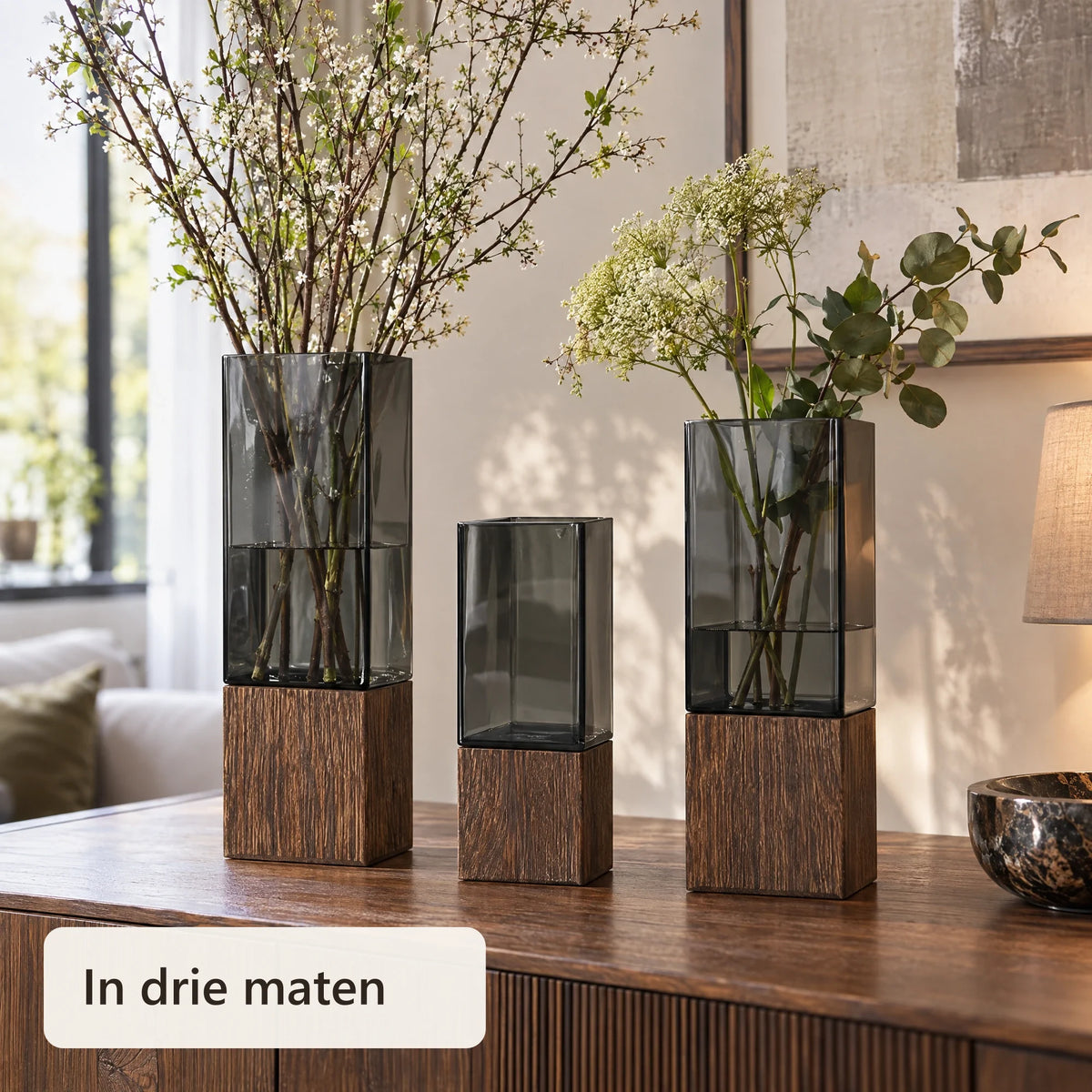 Vazen in verschillende hoogtes met takken op een dressoir