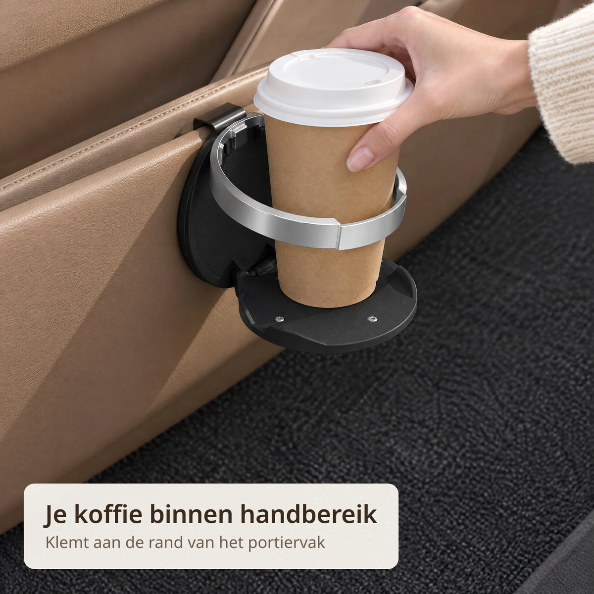 Hand zet een koffiebeker in de zwarte bekerhouder die aan het autoportier klemt