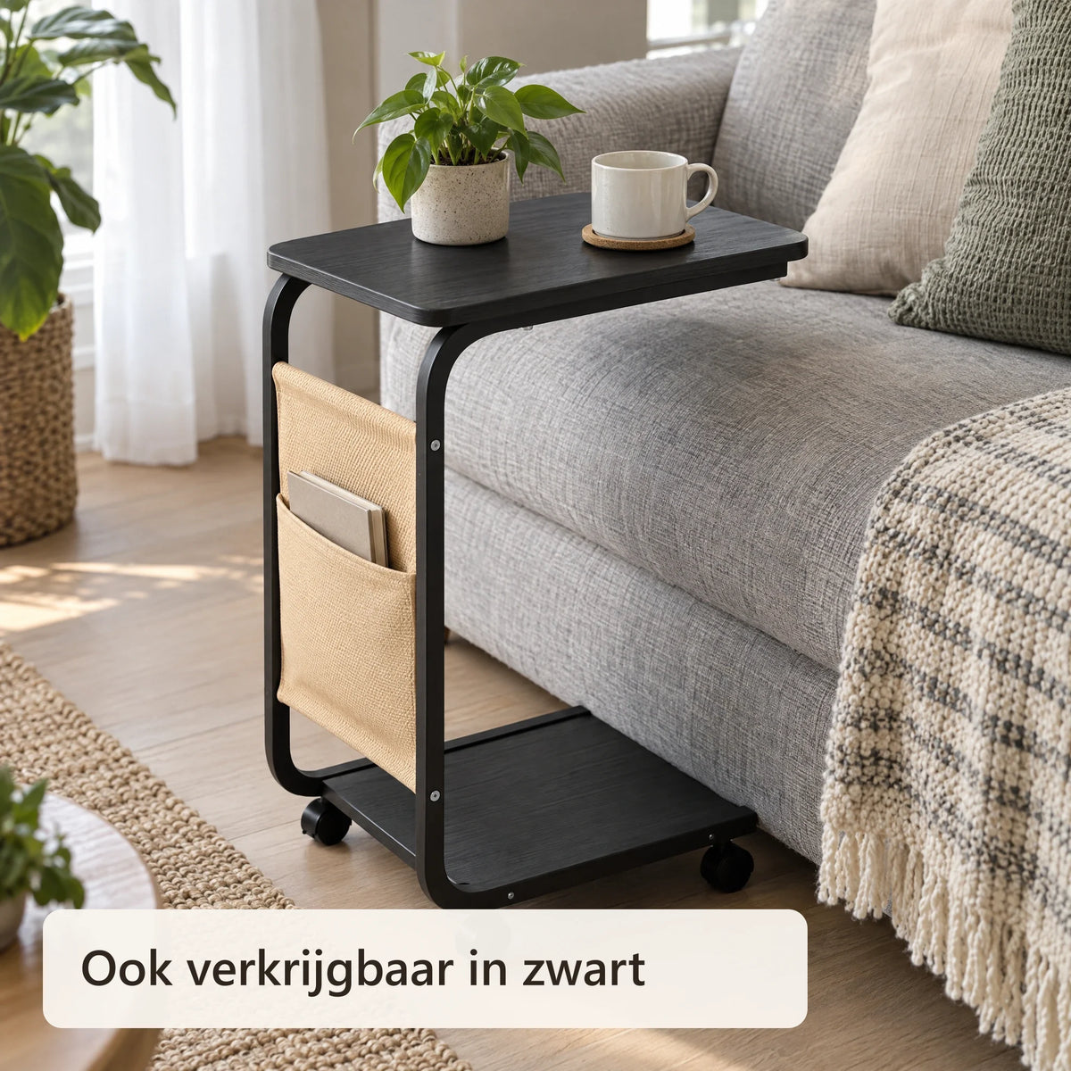 Zwarte bijzettafel in C-vorm naast een grijze bank