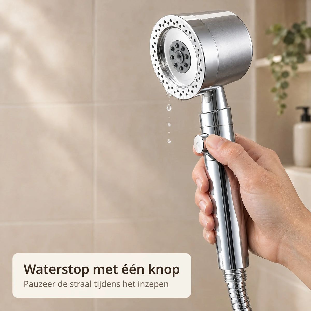 Duim drukt op de stopknop op de handgreep van de douchekop en het water stopt