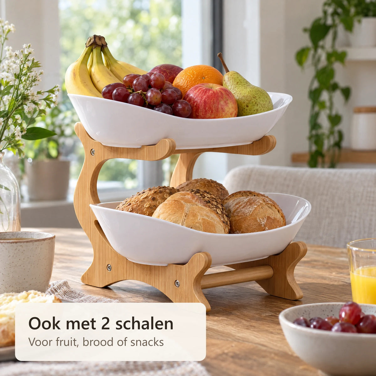 Witte fruitetagère met 2 schalen, broodjes en fruit op tafel