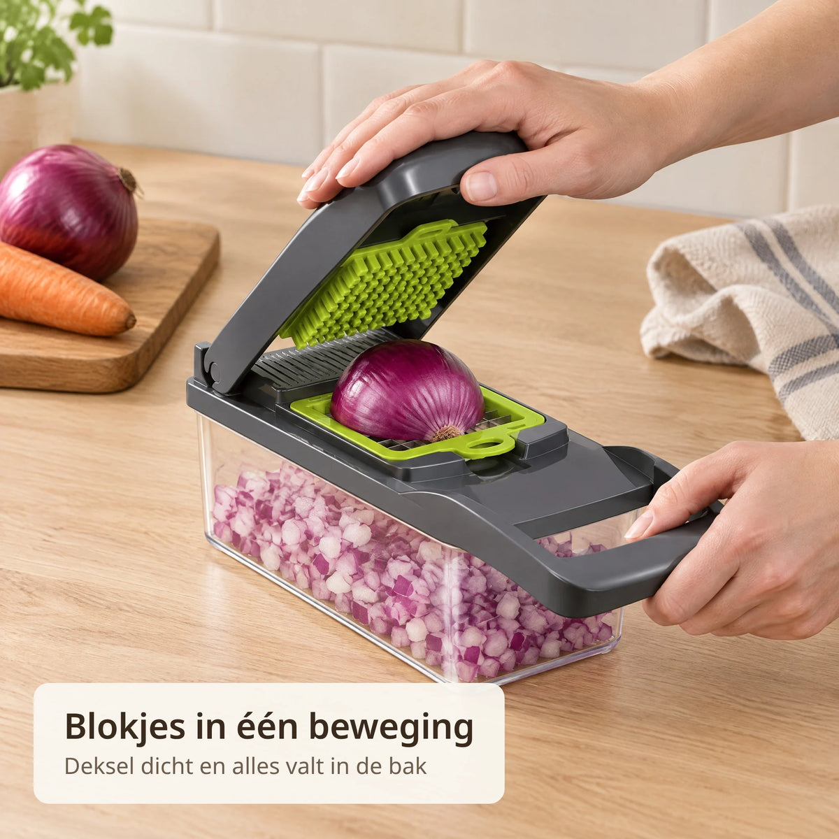 Handen drukken het deksel van de groentesnijder dicht op een halve rode ui, de blokjes vallen in de opvangbak