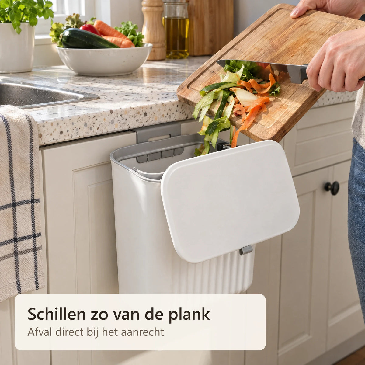 Groenteschillen worden van de snijplank in de afvalbak geveegd