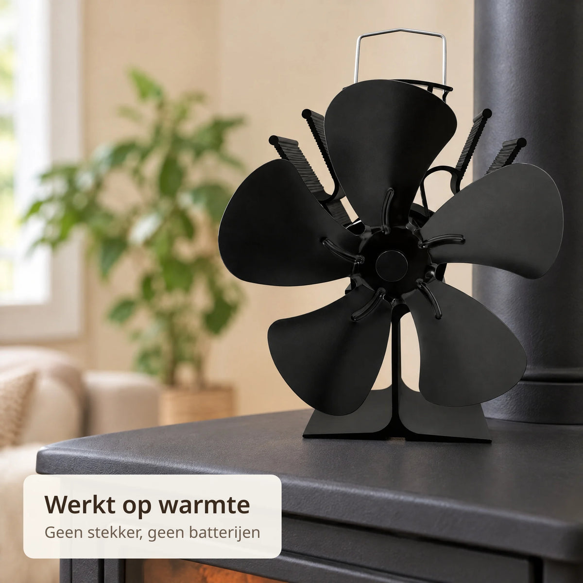 Close-up van de kachelventilator met vijf zwarte bladen en koelribben op de kachelplaat