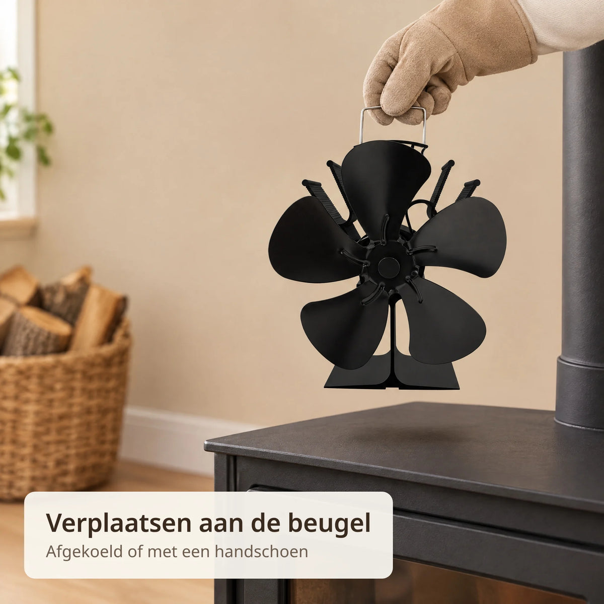 Hand met hittebestendige handschoen tilt de kachelventilator aan de beugel van de houtkachel