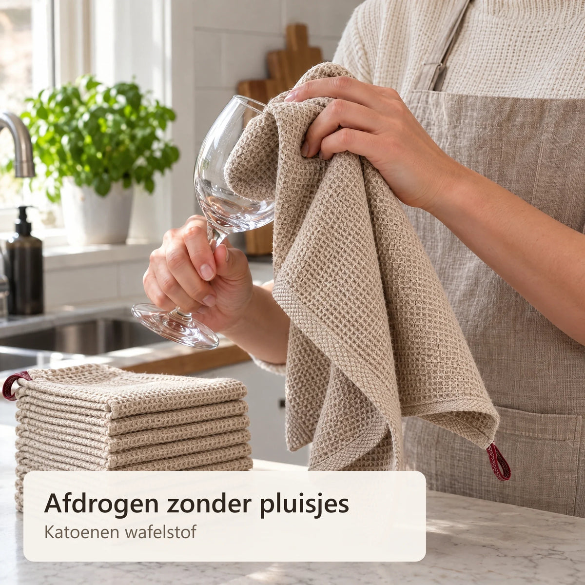 Een wijnglas wordt afgedroogd met een katoenen keukendoek