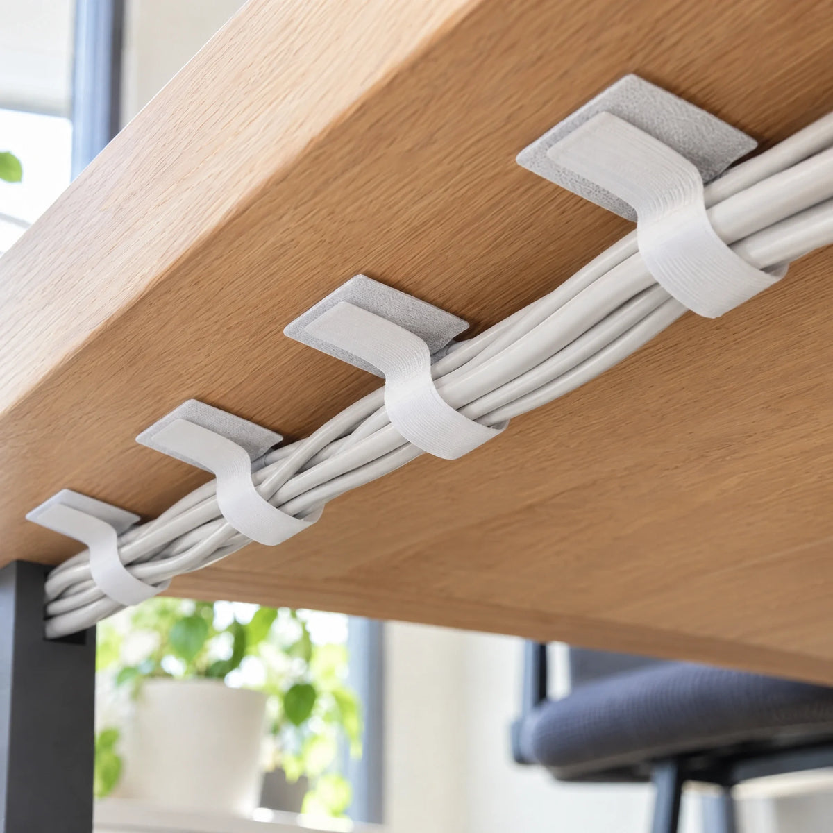 Witte kabelhouders onder een bureau