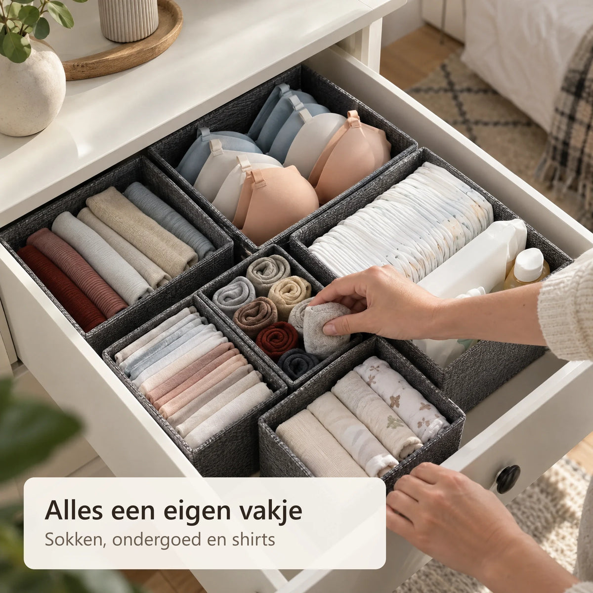 Een hand legt opgerolde sokken in een kleine organizer