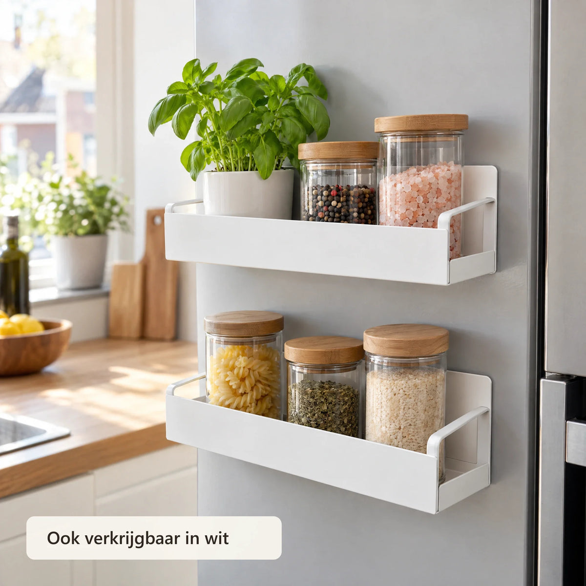 Twee witte magnetische rekken met voorraadpotten en basilicum op een koelkast