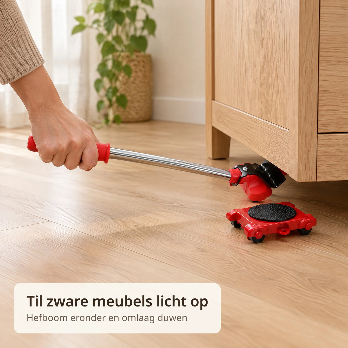 Hand duwt de hefboom van de meubelheffer omlaag onder een eiken kast, met een transportroller klaar naast de hoek