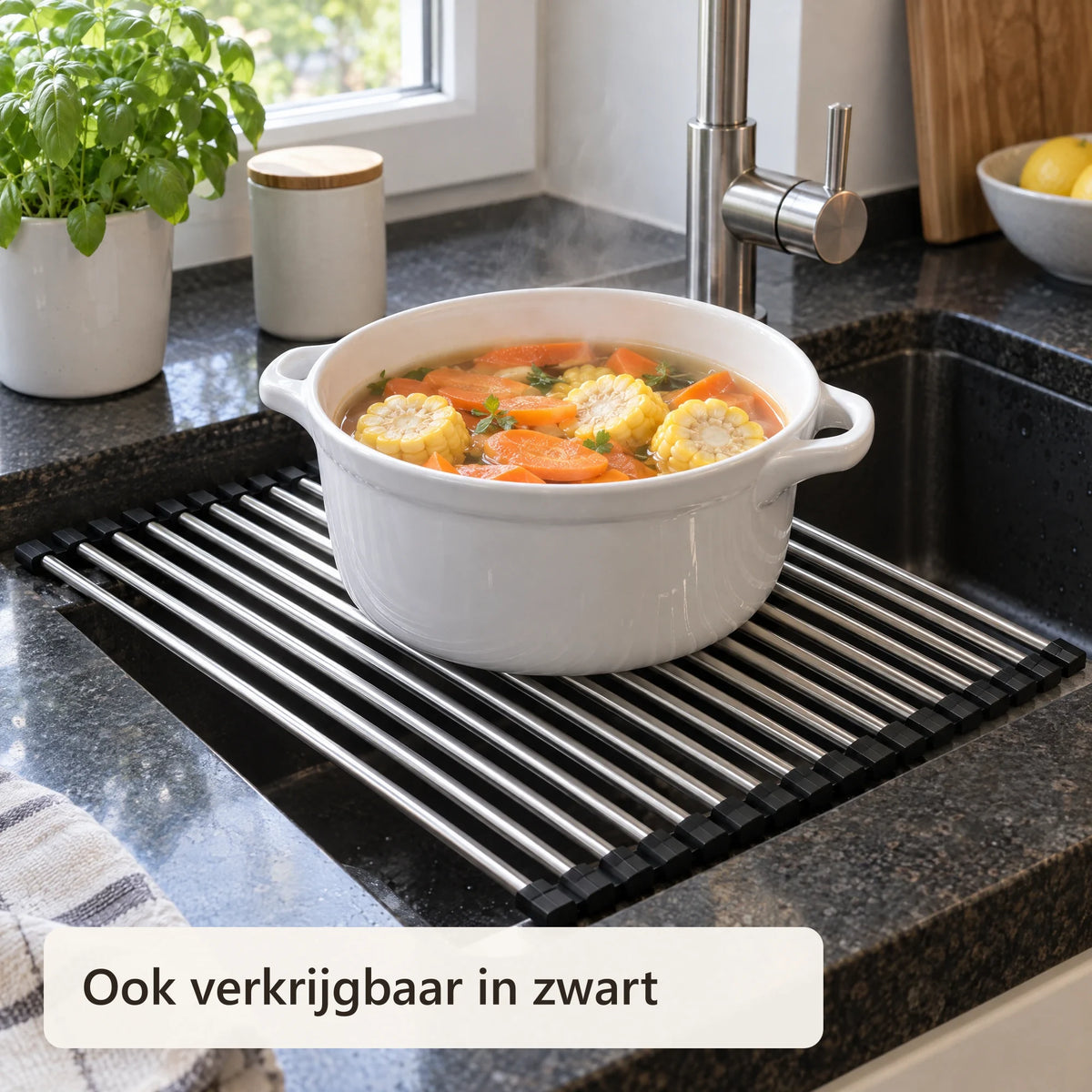 Zwart oprolbaar afdruiprek over een donkere gootsteen