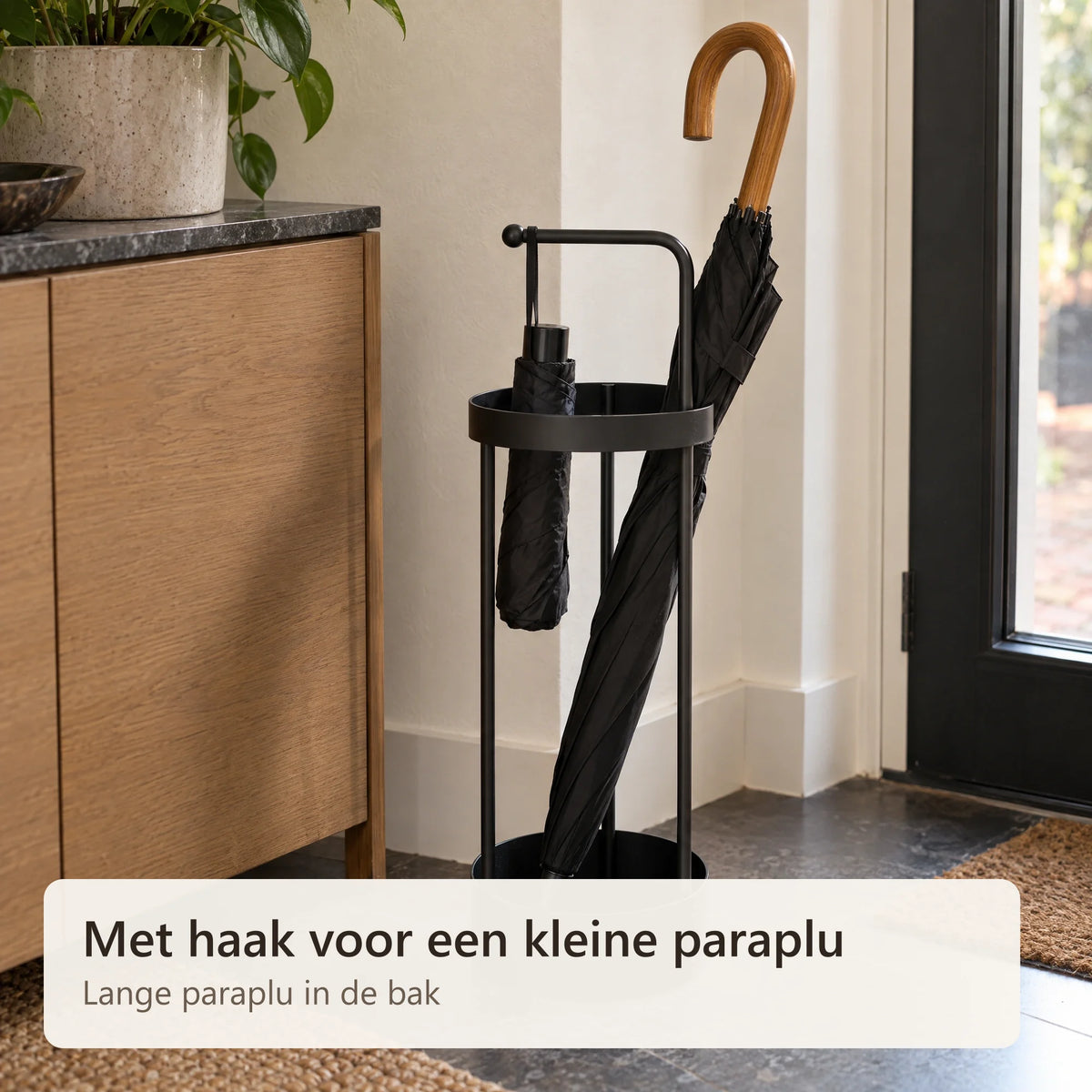 Een opvouwbare paraplu hangt aan de haak van de paraplubak