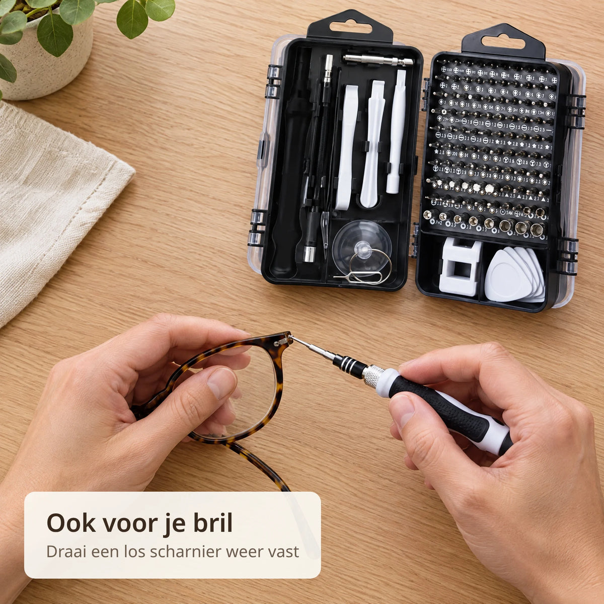 Handen draaien met de precisie schroevendraaier het scharnierschroefje van een bril vast, naast de opengeklapte zwarte case met witte hulpstukken