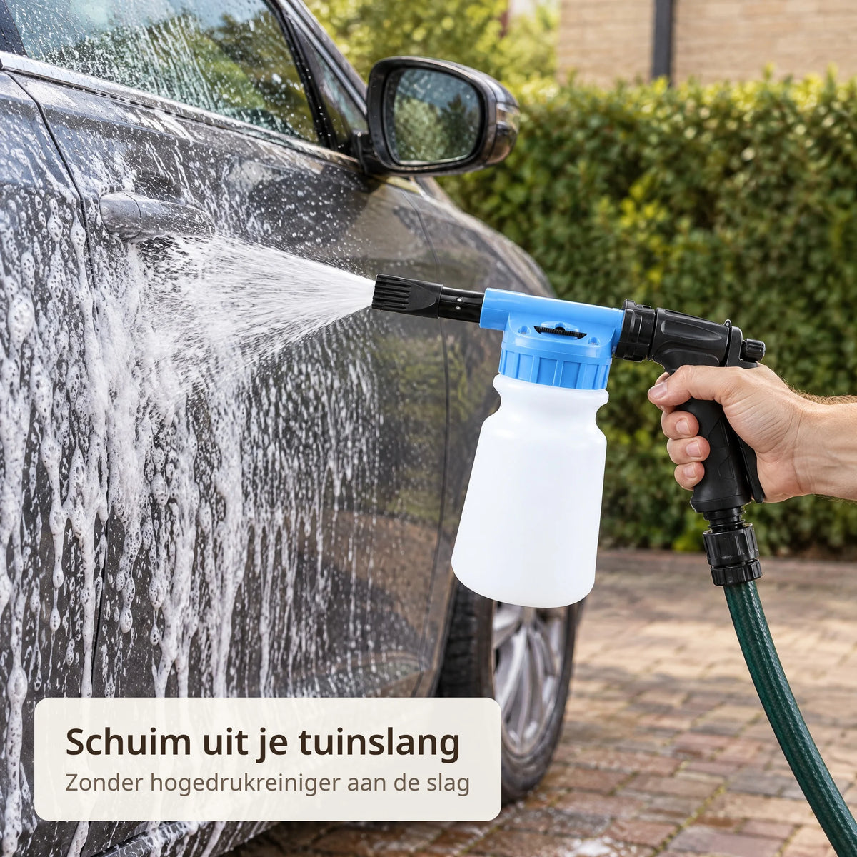 Hand spuit met het schuimpistool aan een tuinslang schuim op het portier van een donkergrijze auto