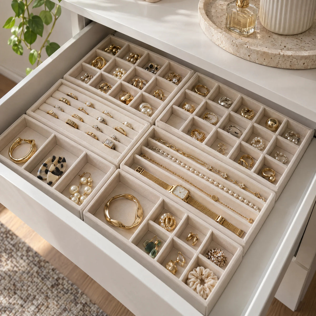 Zes beige sieradentrays met ringen en kettingen in een lade