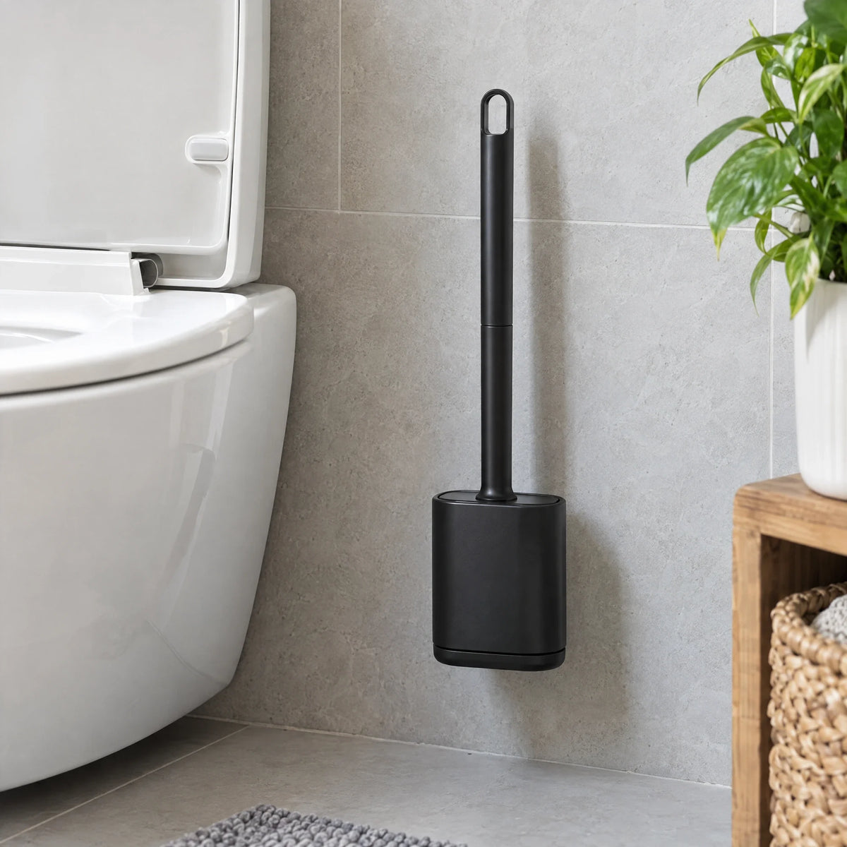 Zwarte siliconen toiletborstel in een wandhouder naast het toilet