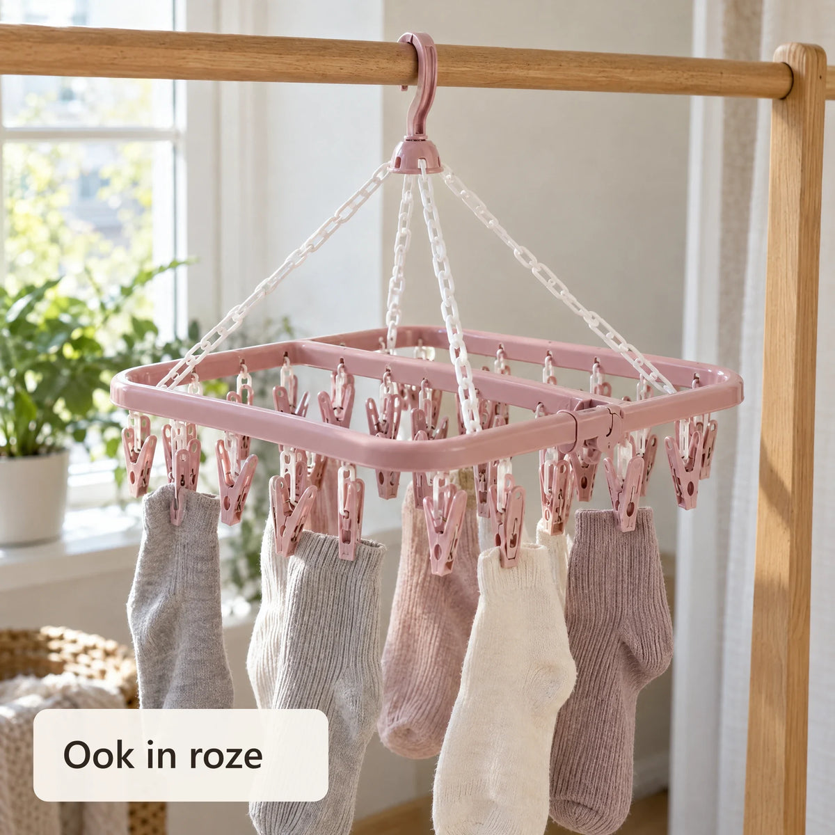Roze sokkendroger met sokken aan een houten stang