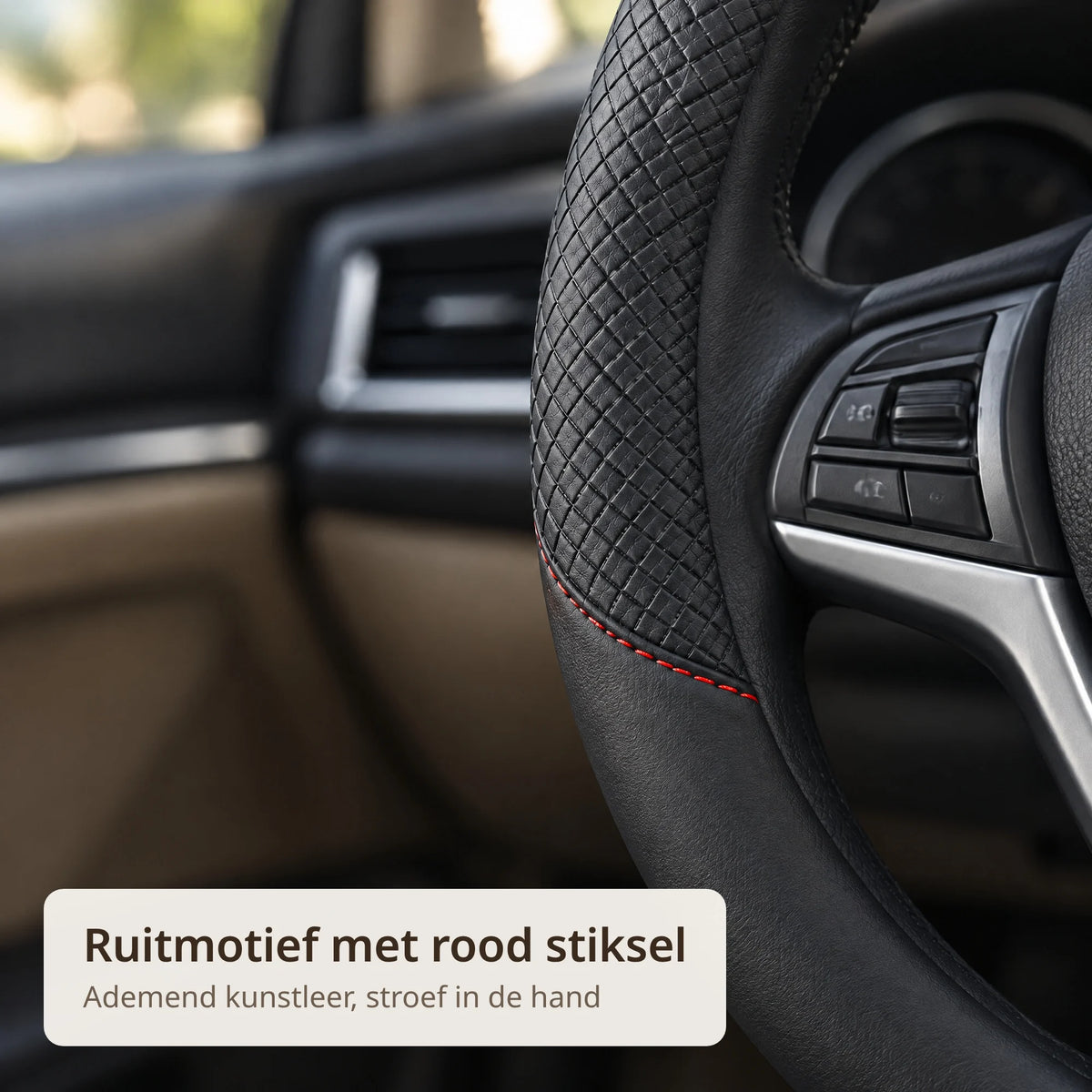 Close-up van de stuurhoes met ruitmotief in zwart kunstleer en rood stiksel
