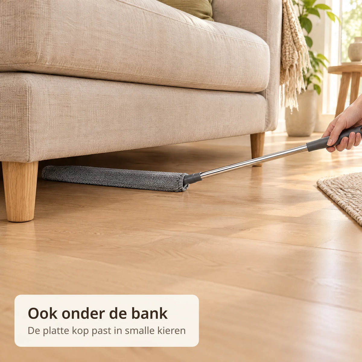 Platte grijze kop van de telescopische plumeau schuift onder een beige bank