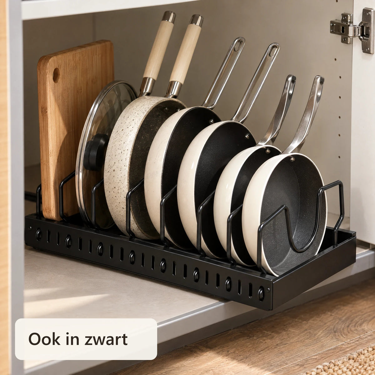 Zwart pannenrek met pannen, deksels en een snijplank
