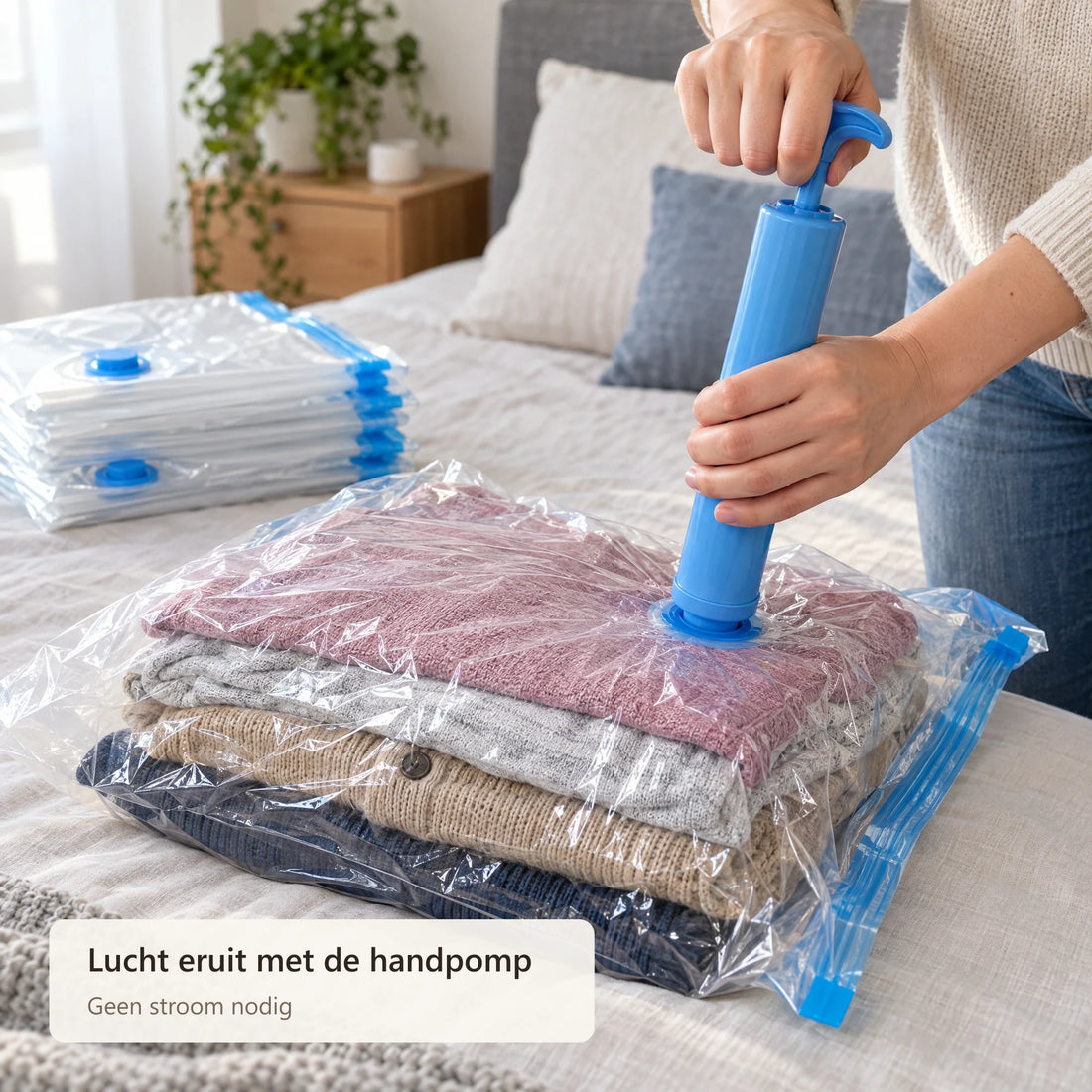 Met de blauwe handpomp wordt de lucht uit een zak met truien gezogen
