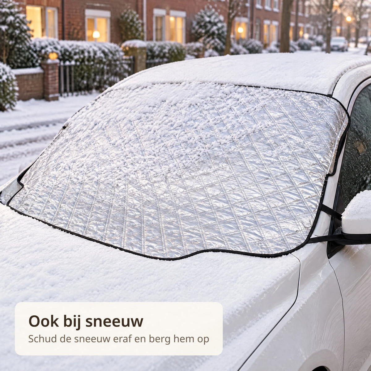 Anti-ijsdeken op de voorruit van een witte auto in een besneeuwde straat