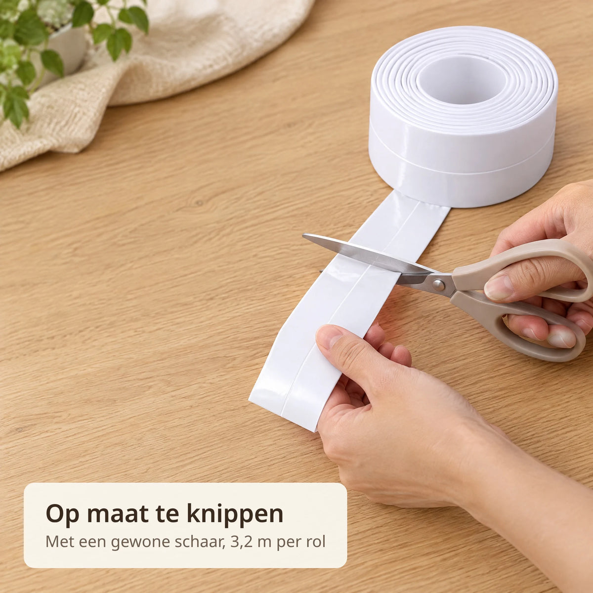 Handen knippen de witte zelfklevende kitstrip met een schaar op maat op een eiken tafel
